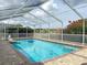Enjoy the refreshing pool enclosed with a screen, surrounded by brick pavers and tasteful landscaping for ultimate privacy at 9253 Water Hazard Dr, Hudson, FL 34667