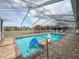 Screened-in pool features a sparkling pool, patio and lovely view of nearby lush foliage at 9253 Water Hazard Dr, Hudson, FL 34667