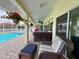 Covered pool area with seating and lush landscaping, perfect for outdoor relaxation at 9253 Water Hazard Dr, Hudson, FL 34667