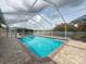 Relax in style in this screened pool area with clear water, paver deck, and lush landscaping for a serene outdoor escape at 9253 Water Hazard Dr, Hudson, FL 34667