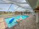 Bask in the sun by this screened in pool with a mermaid statue and beautiful landscaping offering a tranquil outdoor oasis at 9253 Water Hazard Dr, Hudson, FL 34667