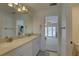 Bright bathroom featuring double sinks, granite counters, and access to a sunroom or patio at 9914 Alavista Dr, Gibsonton, FL 33534