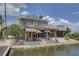 Waterfront home with a white fenced deck, a patio, and tropical landscaping at 9914 Alavista Dr, Gibsonton, FL 33534