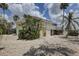 Two story home featuring a covered deck, tropical landscaping, and large driveway at 9914 Alavista Dr, Gibsonton, FL 33534