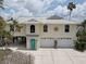 Charming two-story home with a two car garage and decorative sunburst detail under a partly cloudy sky at 9914 Alavista Dr, Gibsonton, FL 33534