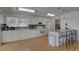 Bright kitchen with white cabinetry, bar seating and includes stainless steel appliances and pantry at 9914 Alavista Dr, Gibsonton, FL 33534