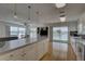 Gourmet kitchen with large center island, white cabinetry, and sliding glass doors to deck with water views at 9914 Alavista Dr, Gibsonton, FL 33534
