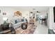 Comfortable living space featuring a sofa, armchairs, cat shelves, and a view into the kitchen at 1003 Carol Ann Pl, Dunedin, FL 34698