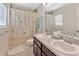 Bright bathroom featuring double sinks, tiled floor, and a shower-tub combo with decorative curtain at 10360 Honeysuckle Vine Cir, Riverview, FL 33578