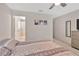 Serene bedroom with a ceiling fan, en-suite bathroom, and neutral color palette at 10360 Honeysuckle Vine Cir, Riverview, FL 33578
