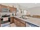 Spacious kitchen with stainless steel appliances, dark wood cabinets and a view into the living room at 10360 Honeysuckle Vine Cir, Riverview, FL 33578