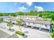 Two-story condo building featuring tropical landscaping, covered parking, and a light gray and white exterior at 1137 King Arthur Ct # 501, Dunedin, FL 34698