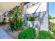 Exterior view of the condo building showcasing the meticulously maintained tropical garden and stone facade at 1137 King Arthur Ct # 501, Dunedin, FL 34698