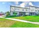 Exterior view of building with lush green lawn and sidewalk at 1137 King Arthur Ct # 501, Dunedin, FL 34698