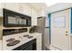 Well-lit kitchen with stainless steel refrigerator and range, plus white cabinets at 1137 King Arthur Ct # 501, Dunedin, FL 34698