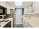 Efficient kitchen featuring white cabinets, stainless steel appliances, and ample counter space at 1137 King Arthur Ct # 501, Dunedin, FL 34698