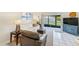 Bright living room with comfortable seating, neutral tones, and access to a screened patio, offering a relaxing ambiance at 1137 King Arthur Ct # 501, Dunedin, FL 34698