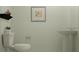 A minimalist half bathroom with pedestal sink, toilet, and neutral decor at 11775 Brae Way, Dade City, FL 33525