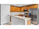 Well-lit kitchen with stainless steel appliances, wood cabinets, and modern countertops at 12028 Citrus Leaf Dr, Gibsonton, FL 33534