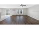 Living room with hardwood floors, sliding glass door, and a modern ceiling fan at 12028 Citrus Leaf Dr, Gibsonton, FL 33534