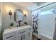 Modern bathroom featuring a white vanity, oval mirror, and shower with a decorative curtain at 1211 64Th Nw St, Bradenton, FL 34209