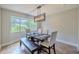 Elegant dining room with a wooden table, upholstered chairs, bench seating, and modern light fixture at 1211 64Th Nw St, Bradenton, FL 34209