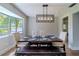 Well-lit dining area with a wood table, upholstered chairs, bench, and a modern hanging light fixture at 1211 64Th Nw St, Bradenton, FL 34209