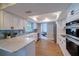 Open kitchen with stainless steel appliances, white cabinets, and marble countertops at 1211 64Th Nw St, Bradenton, FL 34209