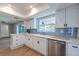 Bright kitchen boasting white cabinets, a blue backsplash, and stainless steel appliances at 1211 64Th Nw St, Bradenton, FL 34209