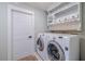 Clean laundry room with shelving above washer and dryer and a doorway at 1211 64Th Nw St, Bradenton, FL 34209