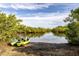 Scenic water view with lush greenery and kayaks on the shore showcasing waterfront living at 1211 64Th Nw St, Bradenton, FL 34209