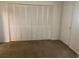 Bedroom with large closet featuring louvered doors and neutral carpet at 1257 Drew St # 15, Clearwater, FL 33755