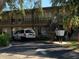 Multi-Gathering building with tan siding, black railings, mature trees, and a parked silver minivan at 1257 Drew St # 15, Clearwater, FL 33755