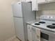 Kitchen with white appliances, white cabinets and granite-style counter tops at 1257 Drew St # 15, Clearwater, FL 33755