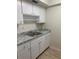Kitchen area with granite-style counter tops, white cabinetry and an open shelf at 1257 Drew St # 15, Clearwater, FL 33755