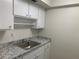 Bright kitchen showcasing white cabinets and a granite-style countertop for a clean, modern look at 1257 Drew St # 15, Clearwater, FL 33755