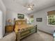 Comfortable bedroom featuring a classic bed frame, ceiling fan, and natural light from two windows at 12669 Eastpointe Dr, Dade City, FL 33525