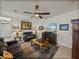 Comfortable living room with ceiling fan, media center, and dark couches over a patterned rug at 12669 Eastpointe Dr, Dade City, FL 33525