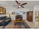 Comfortable living room features a ceiling fan, a media center with a fireplace, and warm lighting at 12669 Eastpointe Dr, Dade City, FL 33525