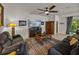 Cozy living room with a large ceiling fan, comfortable seating, and a media center with a fireplace at 12669 Eastpointe Dr, Dade City, FL 33525