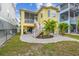 Charming yellow home featuring a screened porch, brick patio, and lush tropical landscaping in the backyard at 1326 Apollo Beach S Blvd, Apollo Beach, FL 33572