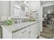 Clean bathroom showcasing a white granite vanity, decorative mirror, and views into adjacent rooms at 1326 Apollo Beach S Blvd, Apollo Beach, FL 33572