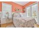 Charming bedroom with coral walls, wainscoting, and sunlit windows at 1326 Apollo Beach S Blvd, Apollo Beach, FL 33572