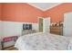 Cozy bedroom with warm coral walls, wainscoting, and hardwood floors at 1326 Apollo Beach S Blvd, Apollo Beach, FL 33572