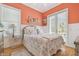 Charming bedroom with coral walls, wainscoting, and sunlit windows at 1326 Apollo Beach S Blvd, Apollo Beach, FL 33572
