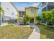 Charming two-story home with a lush green yard, mature palms, and a paver path at 1326 Apollo Beach S Blvd, Apollo Beach, FL 33572