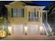 Charming yellow home at night featuring a two-car garage and well-lit exterior at 1326 Apollo Beach S Blvd, Apollo Beach, FL 33572