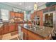 Well-equipped kitchen with stainless steel appliances, granite counters, wood cabinetry, and a functional center island sink at 1326 Apollo Beach S Blvd, Apollo Beach, FL 33572