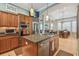 Well-equipped kitchen featuring stainless steel appliances, wood cabinets, granite counters, and an island with sink at 1326 Apollo Beach S Blvd, Apollo Beach, FL 33572