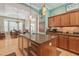Open kitchen featuring wood cabinets, granite countertops, a center island, and views to the dining area at 1326 Apollo Beach S Blvd, Apollo Beach, FL 33572